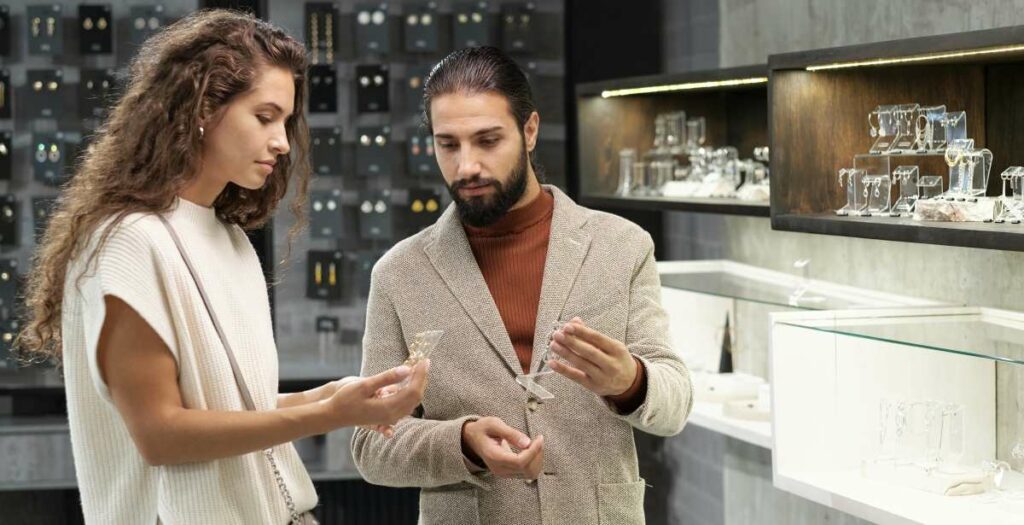Young Man And Woman Consulting About Jewellery In Boutique