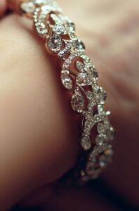 A Close-Up Of A Delicate, Intricately Designed Diamond Bracelet Glimmering In The Light, Nestled On Woman'S Wrist